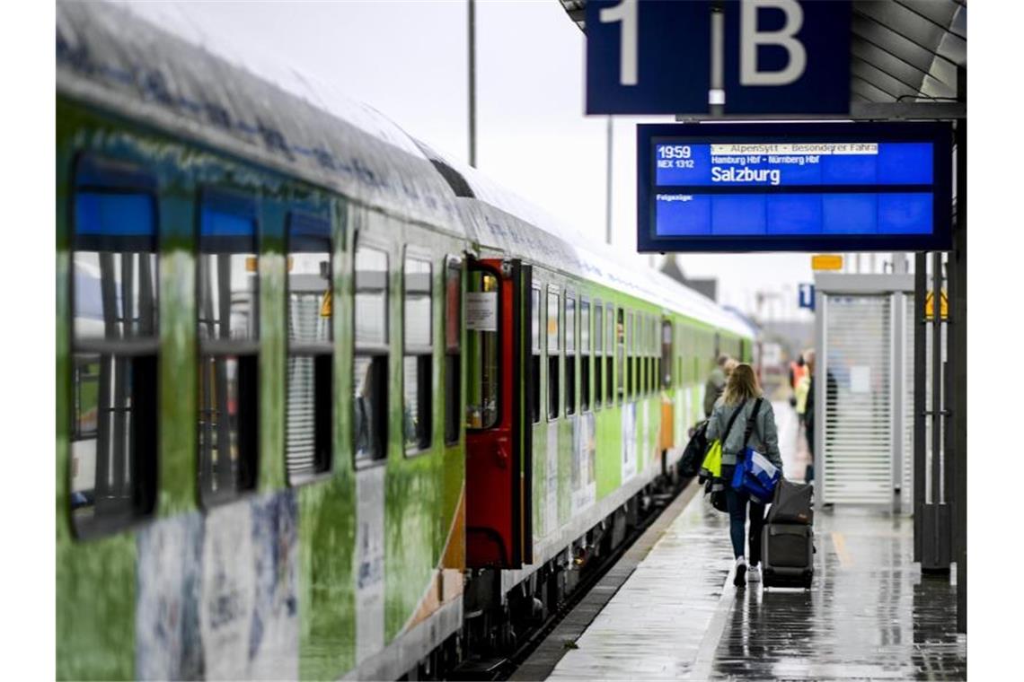 Fahrgäste des neuen Alpen-Sylt-Nachtexpress von Sylt nach Salzburg des Bahnanbieters RDC laufen kurz vor der Abfahrt des Zuges über den Bahnsteig. Foto: Axel Heimken/dpa