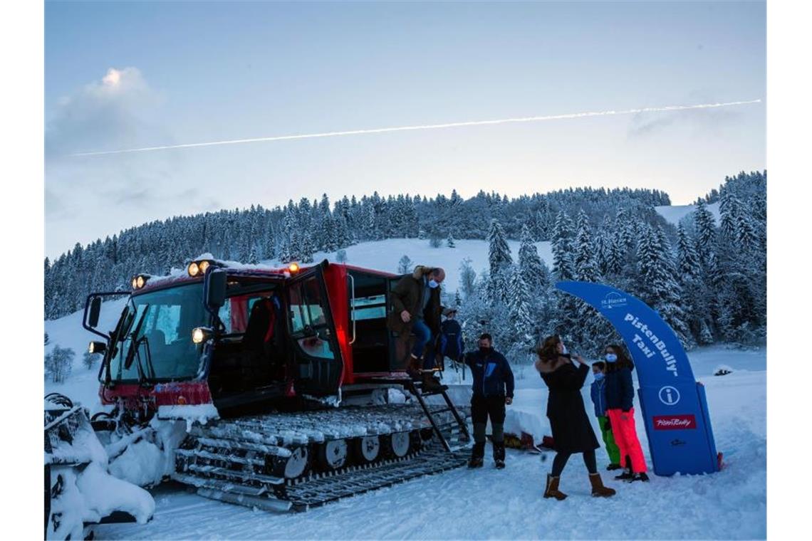 „Pistenbully-Taxi“ bringt Schneefreunde auf den Berg Fahrgäste steigen aus der Fahrgastkabine des Pistenbully aus. Foto: Philipp von Ditfurth/dpa