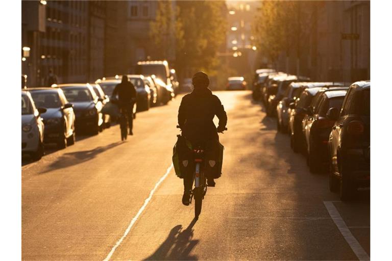 Fahrradfahrer fahren im Morgenlicht. Foto: Sebastian Gollnow/dpa/Archivbild