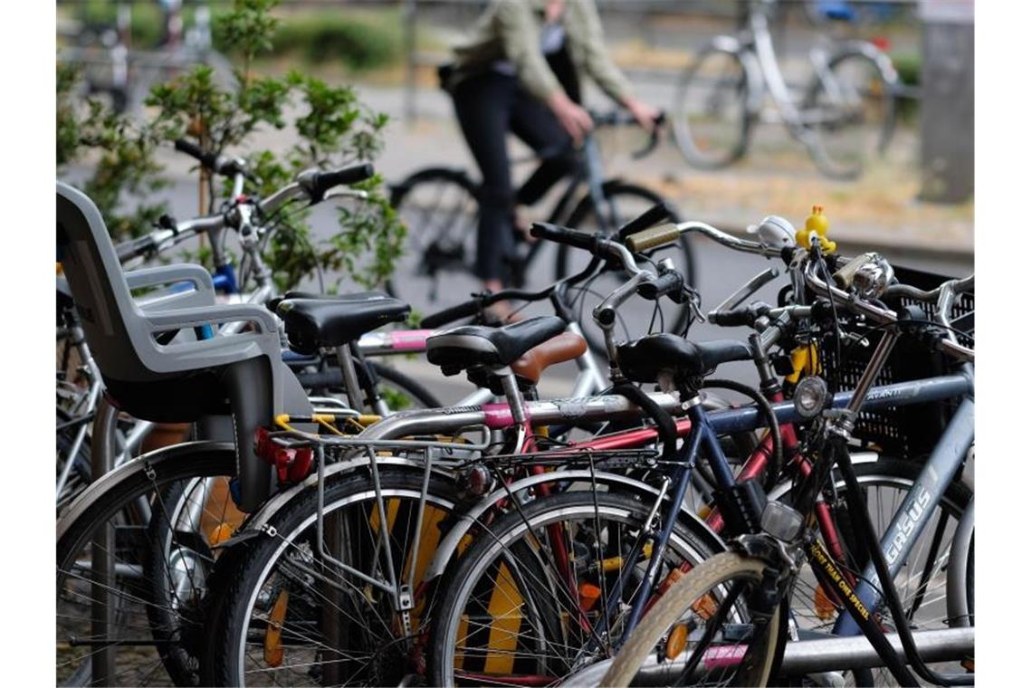 Fahrräder stehen am Rand einer Straße, abgeschlossen an Fahrradbügeln. Foto: Sebastian Willnow/dpa-Zentralbild/dpa/Symbolbild