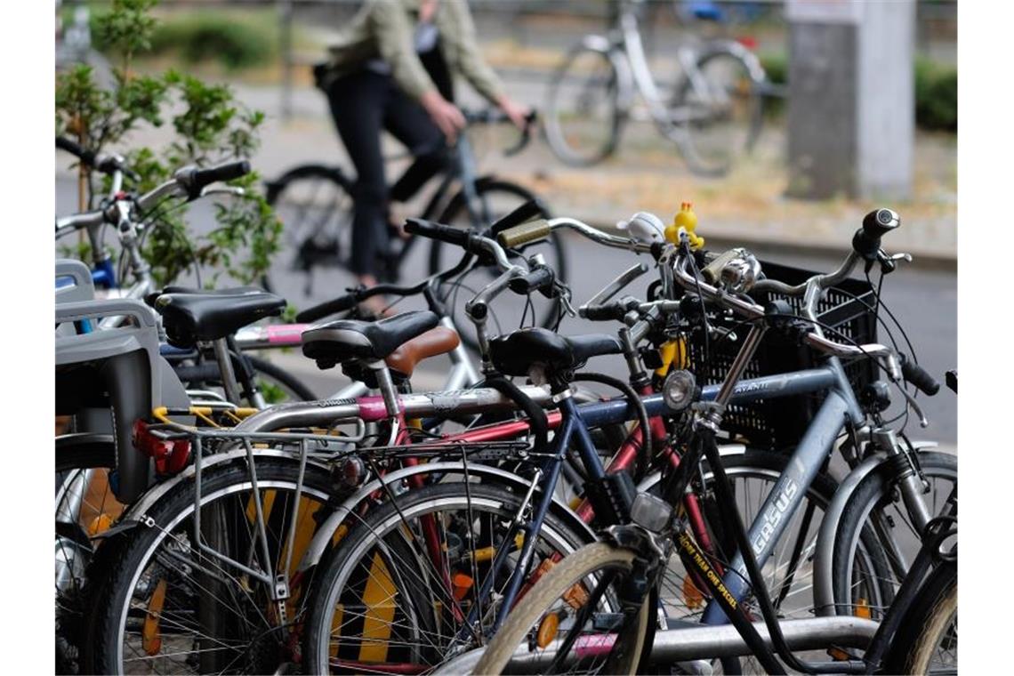 Fahrräder stehen am Rand einer Straße, abgeschlossen an Fahrradbügeln. Foto: Sebastian Willnow/dpa-Zentralbild/dpa/Archiv