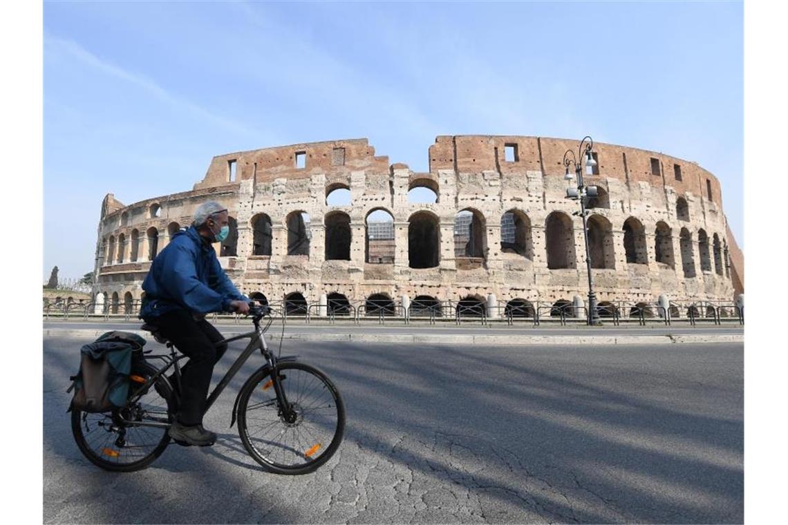Italien: Vorsichtige Hoffnung in Zeiten von Corona Fahrt mit Gesichtsmaske vor dem Kolosseum in Rom. Foto: Elisa Lingria/XinHua/dpa