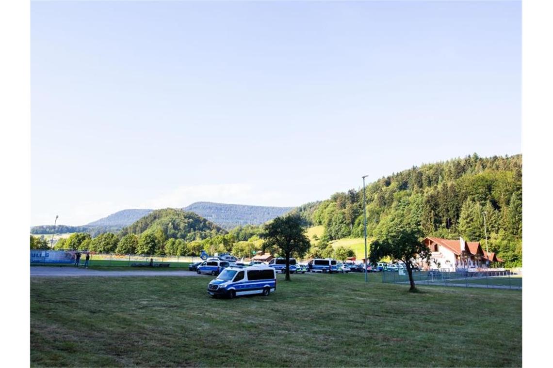 Fahrzeuge der Polizei stehen an einem Sportplatz, der der Polizei als Sammelpunkt dient. Foto: Philipp von Ditfurth/dpa