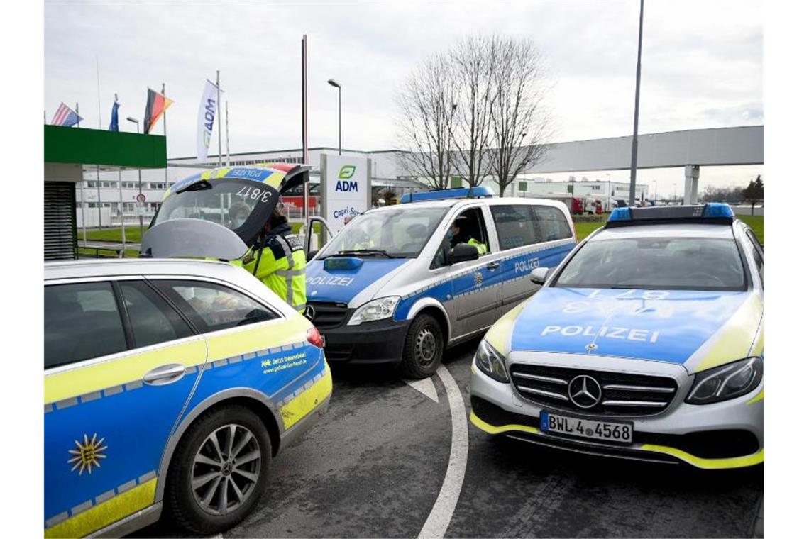 Fahrzeuge der Polizei stehen vor einem Werk eines Getränkeherstellers. Foto: Rene Priebe/dpa/archivbild