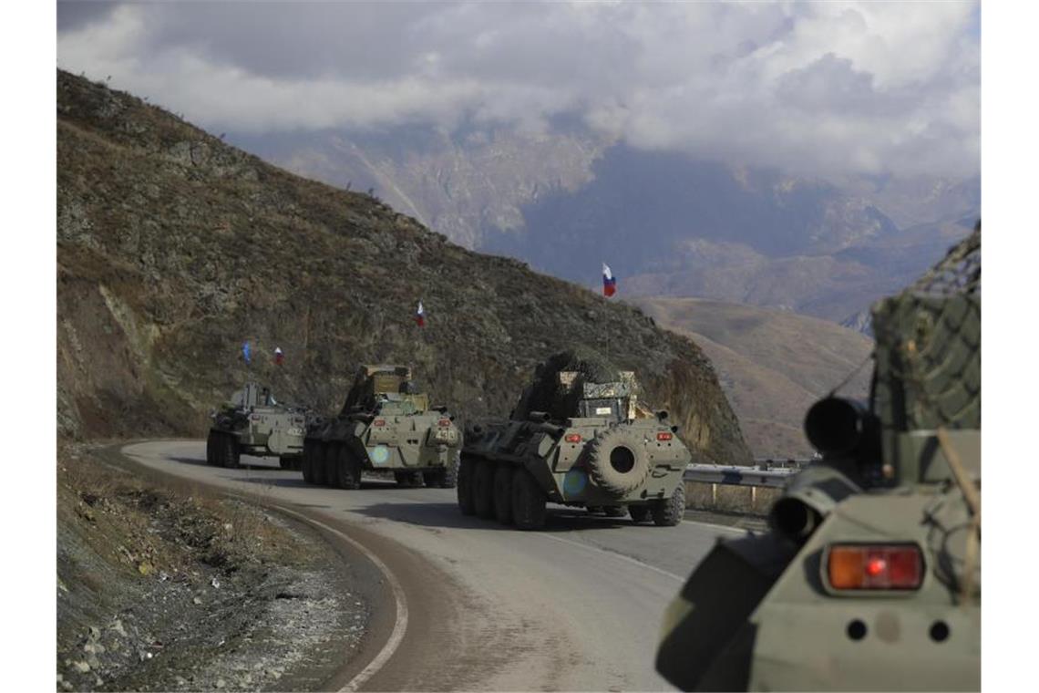 Armenien und Aserbaidschan übergeben getötete Soldaten Fahrzeuge des russischen Militärs fahren über eine Straße in Richtung der separatistischen Region Berg-Karabach. Foto: Sergei Grits/AP/dpa