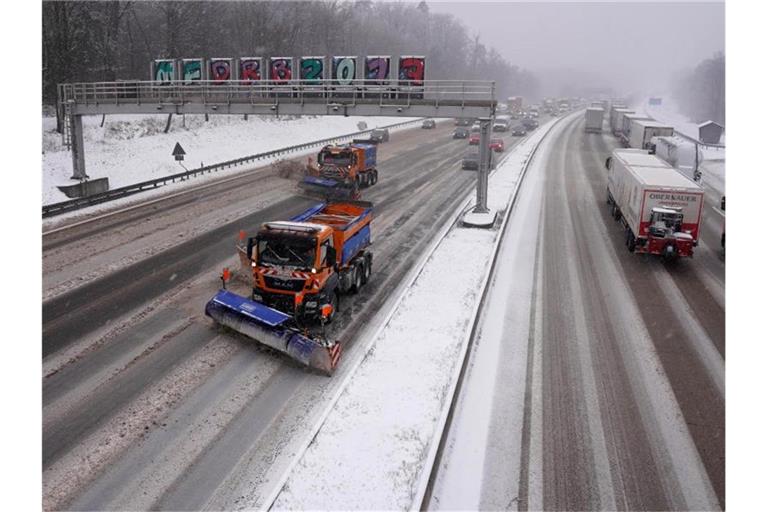 Fahrzeuge des Winterdienstes räumen auf der Autobahn 8 den Neuschnee weg. Foto: Andreas Rosar/dpa