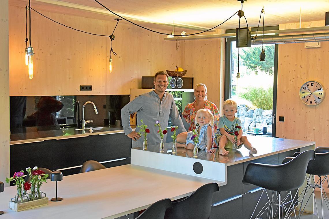 Familie Staudt in ihrer offenen Küche. Weil es keine durchgehenden Wände gibt, werden Kabel und Ähnliches über offene Kanäle unter der Decke geführt. Fotos: Tobias Sellmaier