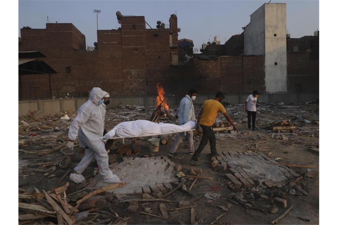 Studie: Millionen mehr Corona-Tote in Indien Familienmitglieder und Freiwillige tragen den Leichnam eines Corona-Opfers zur Einäscherung. Foto: Amit Sharma/AP/dpa/Archivbild