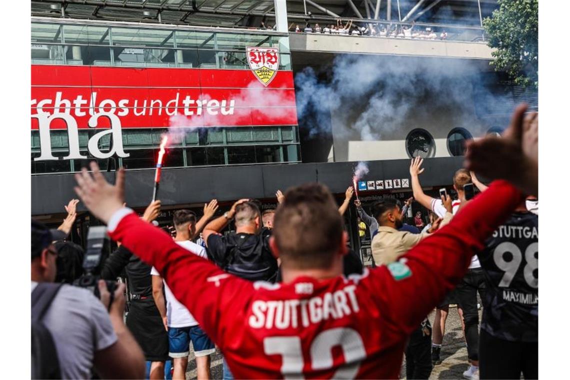 Fans des VfB Stuttgart feiern vor der Mercedes-Benz Arena. Foto: Christoph Schmidt/dpa