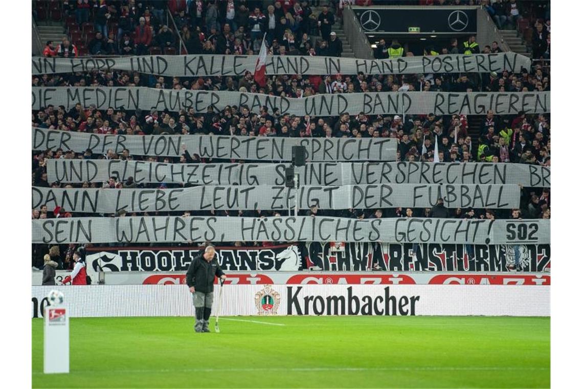 Fans des VfB Stuttgart halten ein Banner nach oben. Foto: Sebastian Gollnow/dpa