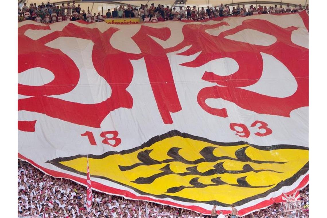 Fans halten einen Banner mit dem Logo des VfB Stuttgart. Foto: Sebastian Kahnert/Archivbild