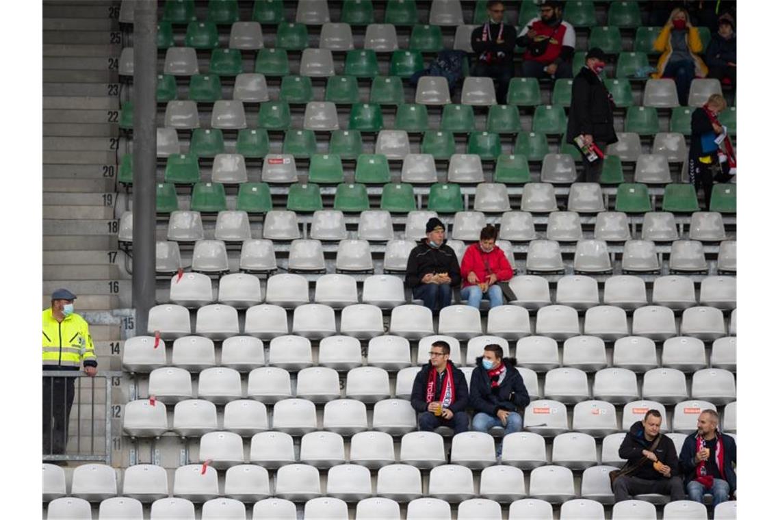 Fans sitzen mit Abstand auf einer Tribüne im Schwarzwald-Stadion. Foto: Tom Weller/dpa/Archivbild
