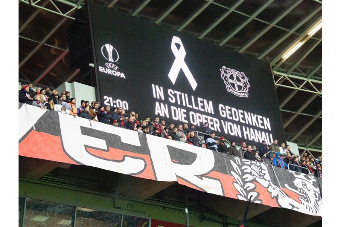 Fans stehen für eine Schweigeminute für die Opfer von Hanau auf der Tribüne. Foto: Federico Gambarini/dpa