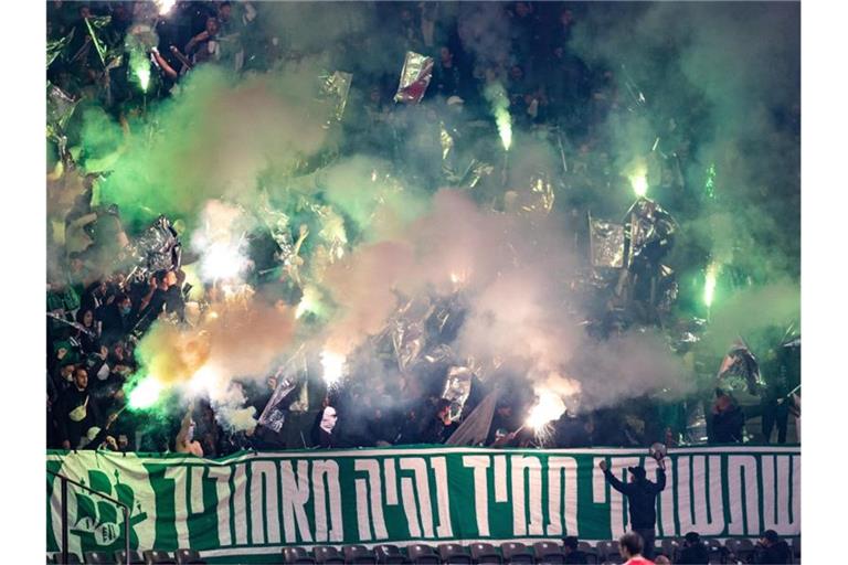 Fans von Maccabi Haifa zünden Bengalisches Feuer im Olympiastadium Berlin. Foto: Andreas Gora/dpa