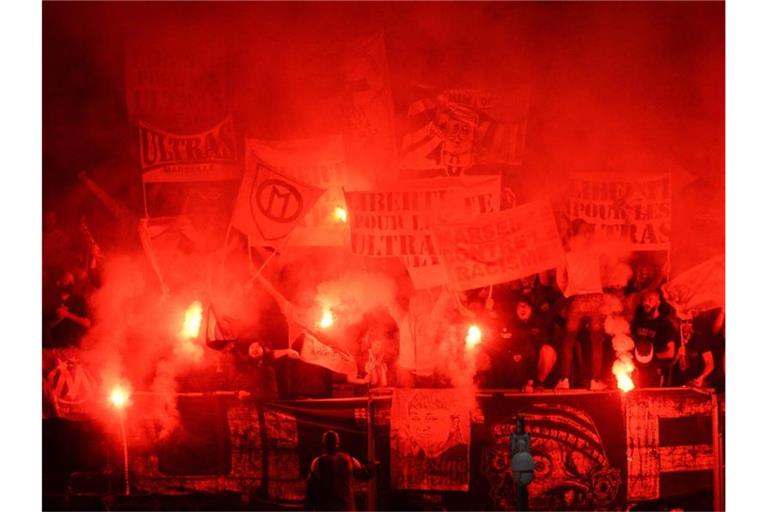 Fans von Marseille zünden Pyrotechnik während des Spiels in Angers. Nach dem Spiel gingen die Anhänger beider Clubs aufeinander los. Foto: Jean-Francois Monier/AFP/dpa