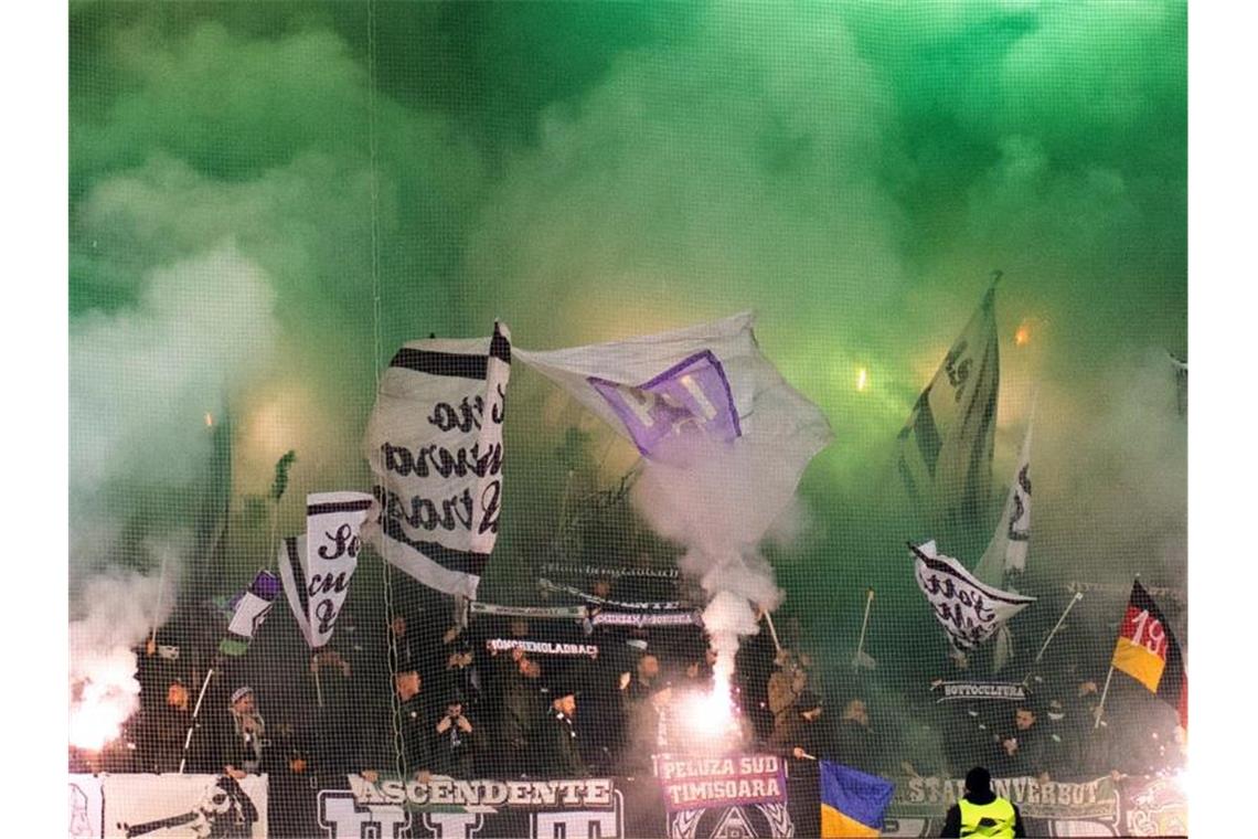 Fans von Mönchengladbach zünden Pyrotechnik auf der Gästetribüne des Wolfsberger AC. Foto: Marcel Kusch/dpa