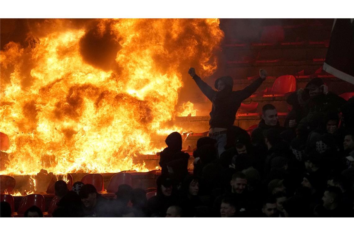 Fans von Partizan Belgrad jubeln vor brennenden Sitzen während des Derbys in der serbischen Fußballliga gegen Roter Stern Belgrad.