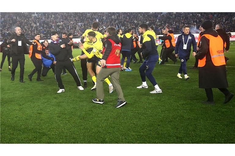 Fans von Trabzonspor haben das Spielfeld gestürmt und Spieler von Fenerbahce angegriffen.