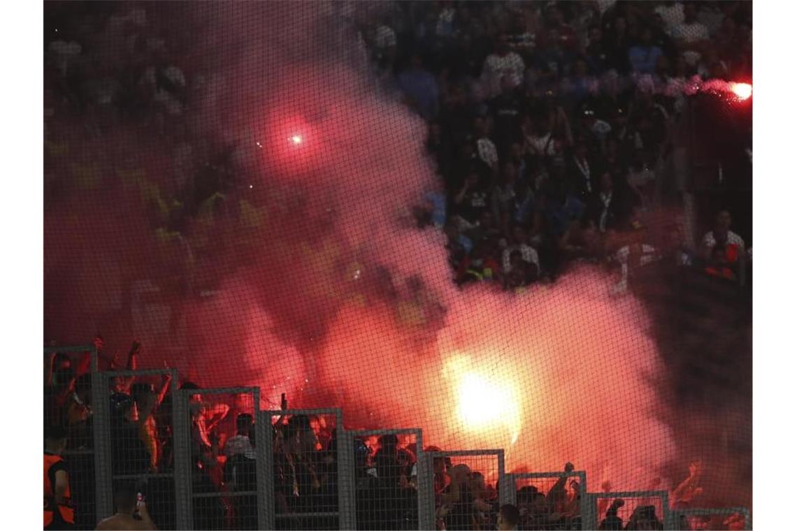 Pyros, Polizisten, Festnahmen: Wieder Randale in Frankreich Fans zündeten Bengalos während des Fußballspiels im Stadion Stade Velodrome in Marseille an. Foto: Daniel Cole/AP/dpa