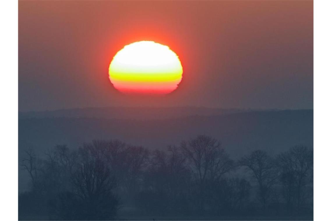 Nass-trüber Start in die neue Woche Farbenprächtig leuchtet die Morgensonne über einer Landschaft. Foto: Patrick Pleul/dpa-Zentralbild/ZB