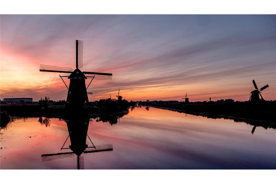 Farbenspiel: Der Himmel hinter Windmühlen in Kinderdijk, Niederlande, ist bunt verfärbt. Die Windmühlen sind Teil von 19 Mühlen, die im 18. Jahrhundert südlich von Rotterdam gebaut wurden.