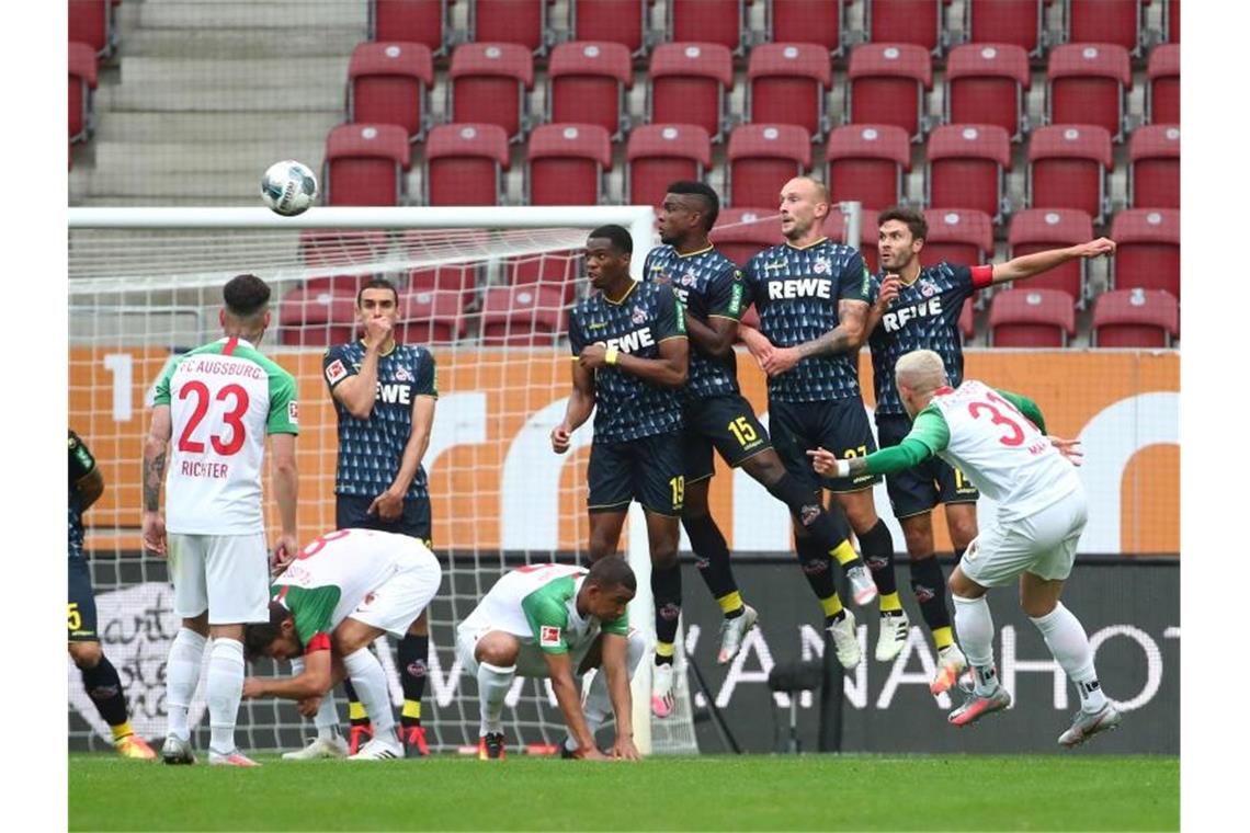 FC Augsburgs Philipp Max schießt den Freistoß über die Mauer aufs Tor. Foto: Michael Dalder/Reuters-Pool/dpa