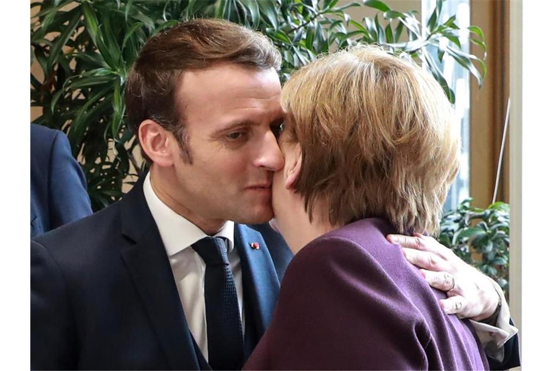 EU-Sondergipfel ringt um Kompromiss im Haushaltsstreit Feilschen ums Geld in aller Freundschaft: Frankreichs Präsident Emmanuel Macron begrüßt Angela Merkel am Rande des EU-Gipfels der Staats- und Regierungschefs. Foto: Ludovic Marin/AFP Pool/AP/dpa