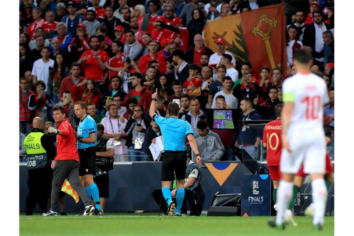 Felix Brych (M.) gab nach Videobeweis Strafstoß für die Schweiz, obwohl er einen für Portugal gepfiffen hatte. Foto: Mike Egerton/PA Wire