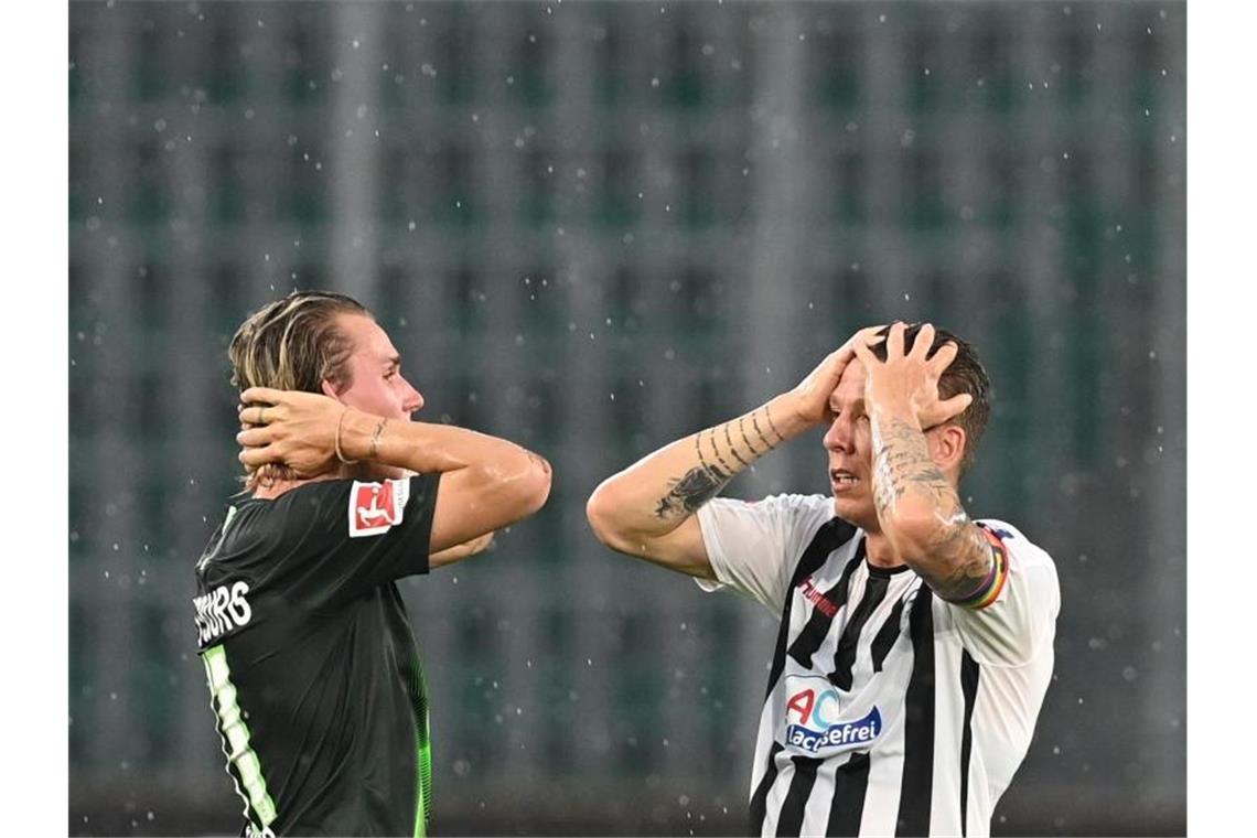 Reaktionen zum Spiel VfL Wolfsburg - SC Freiburg (2:2) Felix Klaus (l) und Mike Frantz stehen enttäuscht auf dem Platz. Foto: Sascha Steinbach/epa Pool/dpa