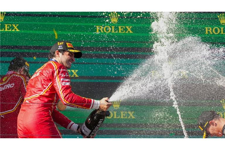 Ferrari-Pilot Carlos Sainz feiert mit Champagner seinen Sieg.