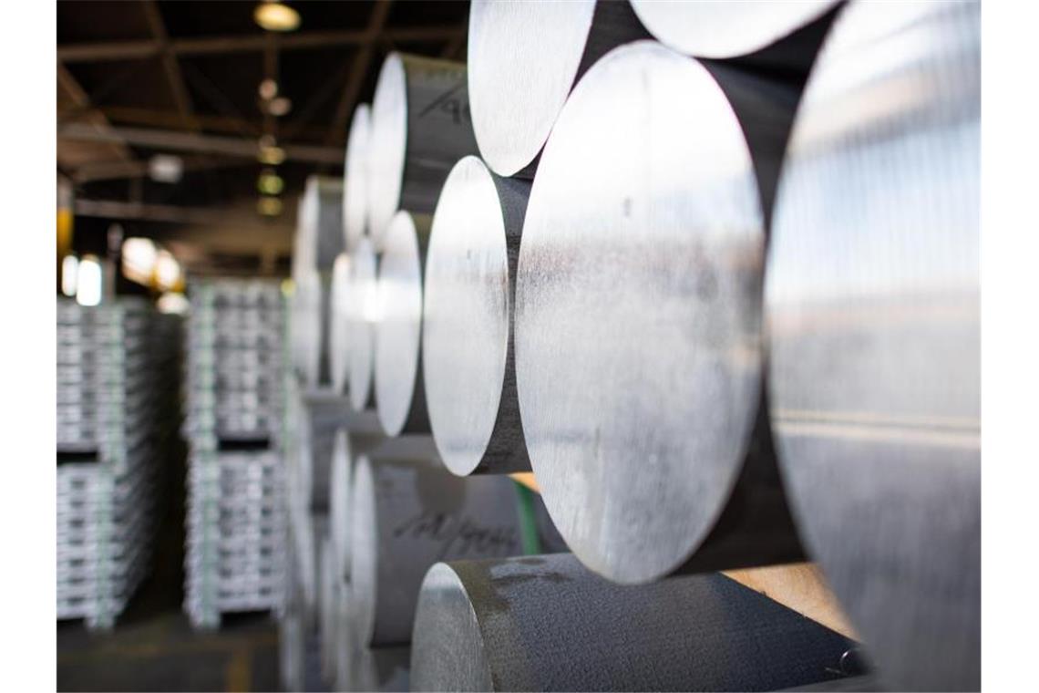 Fertig produzierte Aluminiumstangen stehen zum Abtransport in einem Lager. Foto: Guido Kirchner/dpa