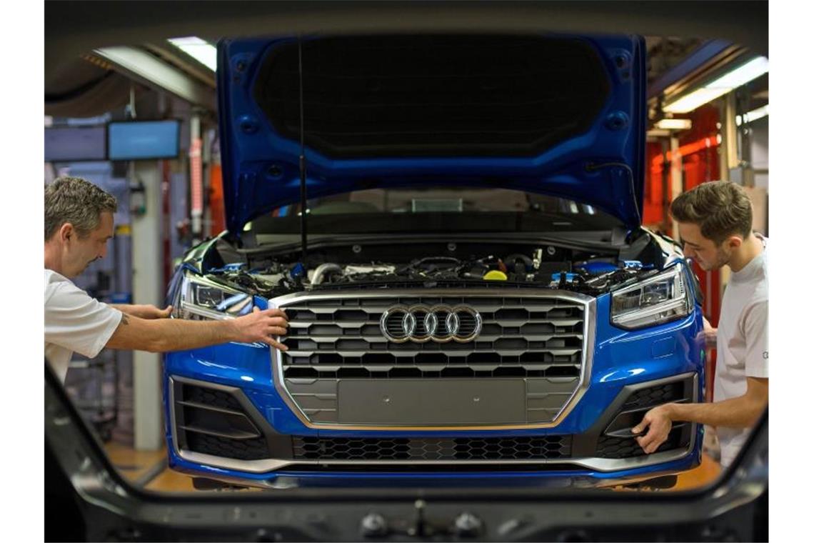 Fertigungsmechaniker bringen an einem Fließband im Audi-Werk die Front an einem Audi an. Foto: Andreas Gebert/dpa/Archivbild