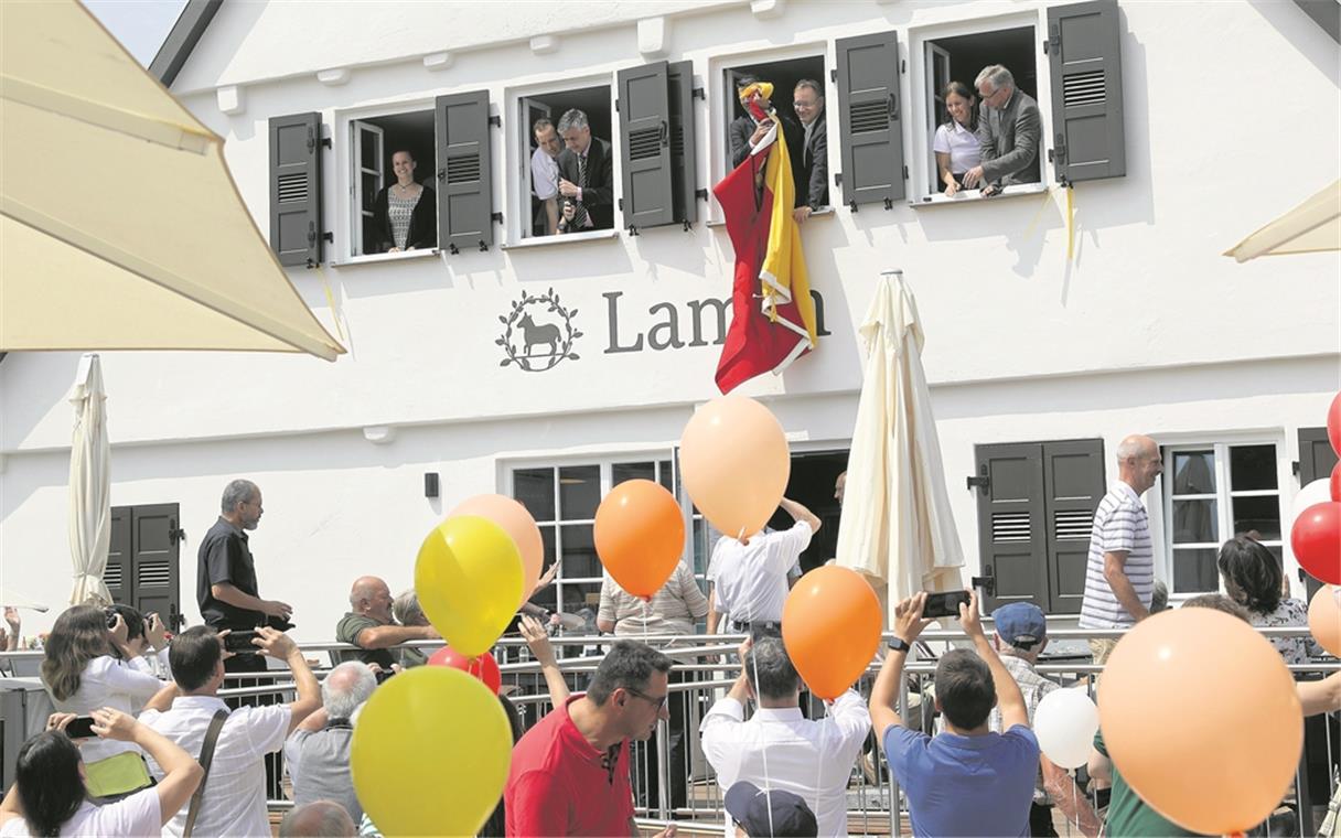 Fest, Fahne und Luftballons fürs Lamm Fest zum Sanierungsende des Wirtshauses Lamm am Löwenplatz: Bürgermeister Jürgen Kiesl hängt die Gemeindeflagge auf. Foto: B. Büttner