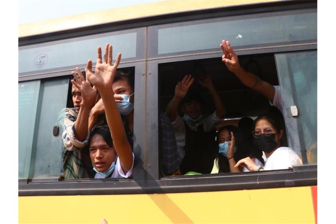 Rund 600 Studenten in Myanmar freigelassen Festgenommene Demonstranten winken Menschen, während sie in einem Bus sitzen, der aus dem Insein-Gefängnis kommt und sie zu einem ungenannten Ort transportieren wird. Foto: Uncredited/AP/dpa