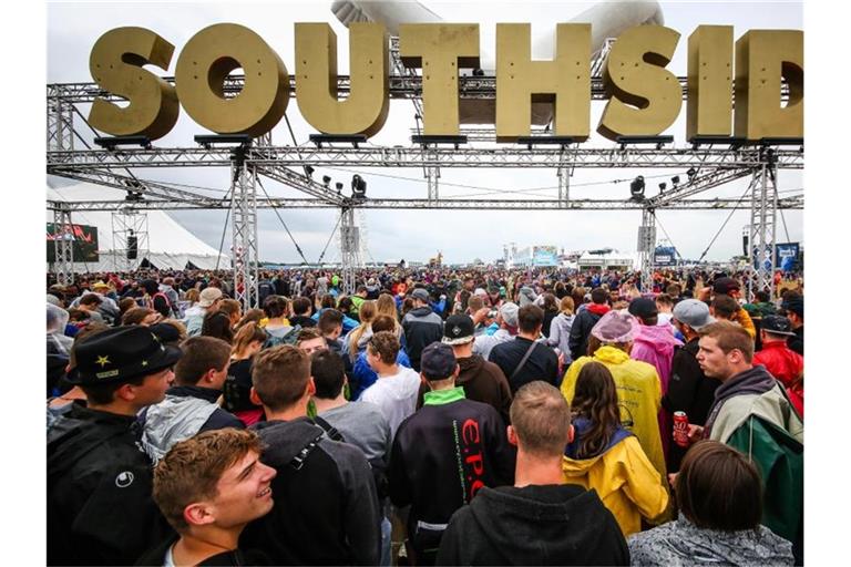 Festivalbesucher stehen unter dem Schriftzug „Southside“. Foto: Christoph Schmidt/dpa/Archivbild