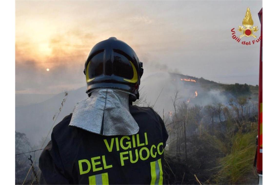 Feuer auch in Italien: Ein Feuerwehrmann beobachtet einen Waldbrand. Foto: Vigili del Fuoco/dpa