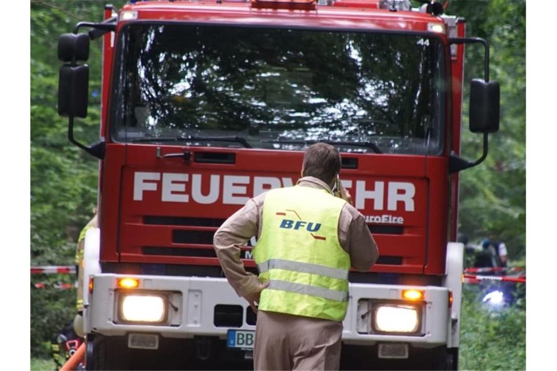 Feuerwehr und ein Mitarbeiter der BFU stehen an der gesperrten Zufahrt zum Gebiet, in dem ein Kleinflugzeug abgestürzt ist. Foto: Sdmg / Dettenmeyer/SDMG/dpa