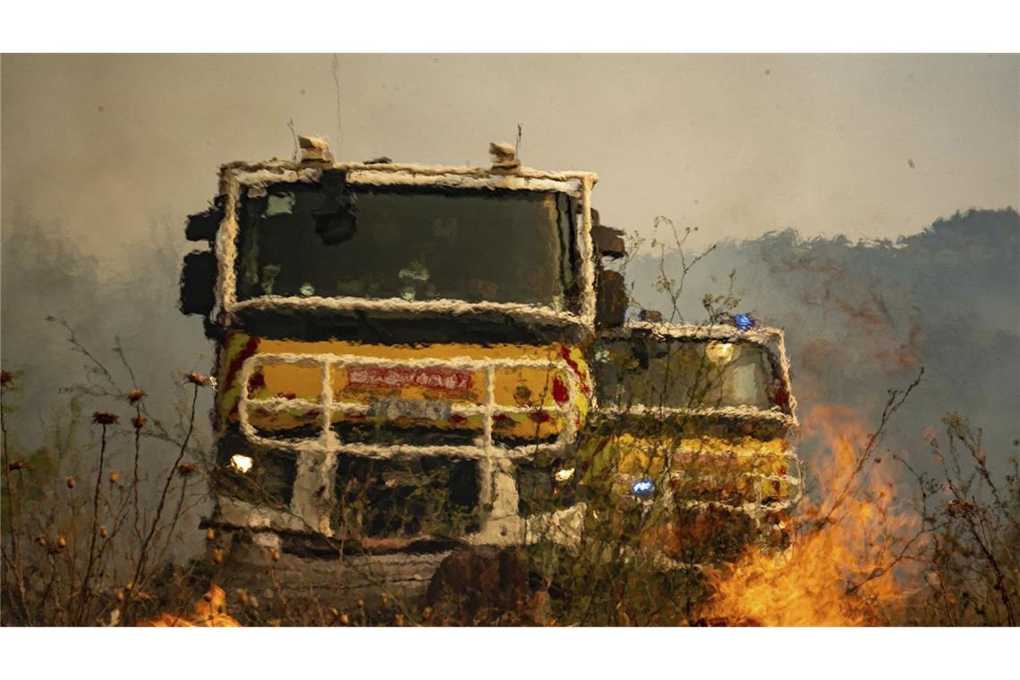 Feuerwehrfahrzeuge neben dem Waldbrand in der Nähe von Saint-Laurent-de-la-Cabrerisse in Südfrankreich.