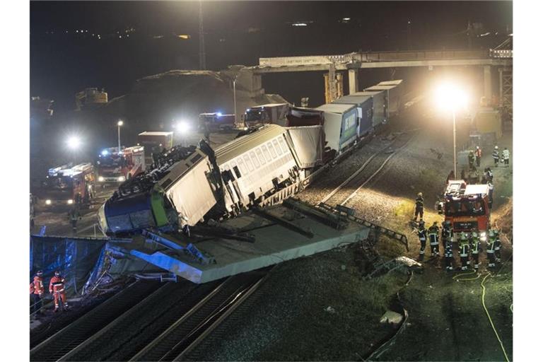 Feuerwehrfahrzeuge stehen um den verunglückten Zug. Foto: Patrick Seeger/dpa