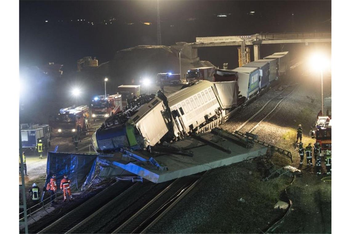 Polizei ermittelt nach tödlichem Zugunglück Feuerwehrfahrzeuge stehen um einen verunglückten Zug. Foto: Patrick Seeger/dpa