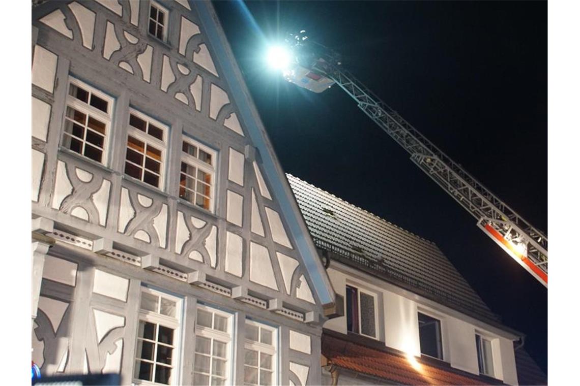 Feuerwehrkräfte untersuchen das historische Haus nach dem Brand. Foto: Gress/SDMG/dpa