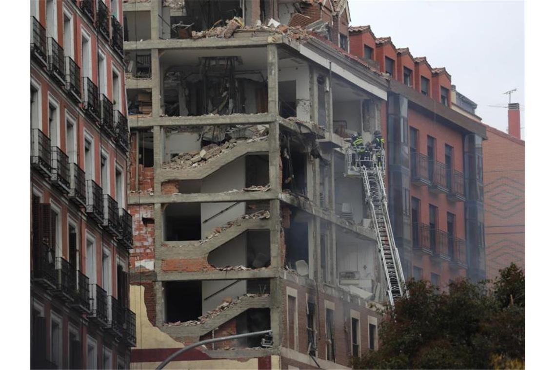 Feuerwehrleute arbeiten nach der schweren Explosion an dem beschädigten Gebäude in Madrids Toledo Straße. Foto: Manu Fernandez/AP/dpa