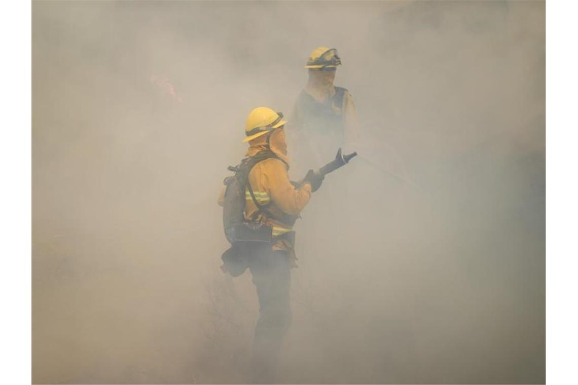 Feuerwehrleute bei den Löschversuchen eines Feuers im US-Bundesstaat Kalifornien. Foto: Jae C. Hong/AP/dpa