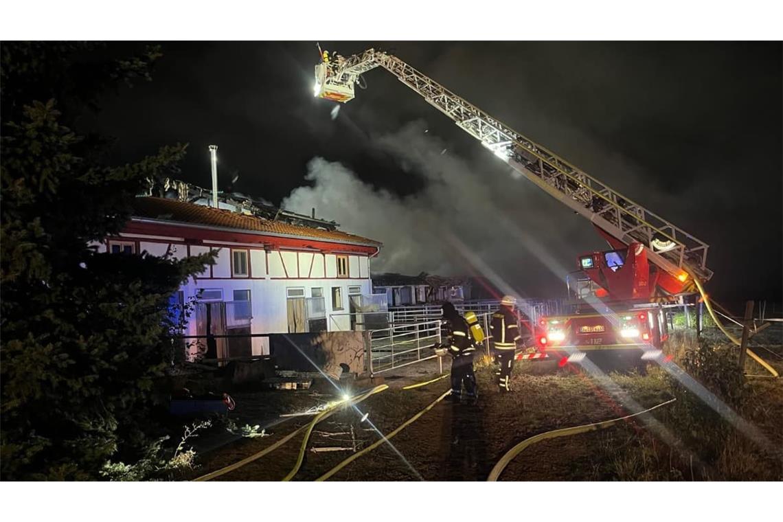 Feuerwehrleute bekämpfen die Flammen auf dem Reiterhof: Das Feuer griff auf einen Stall über.