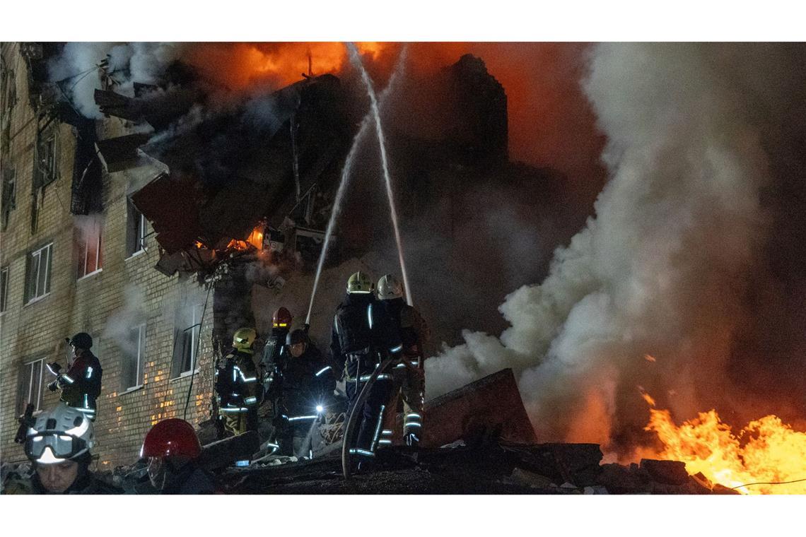 Feuerwehrleute bekämpfen einen Brand in einem Mehrfamilienhaus nach einem russischen Raketenangriff.