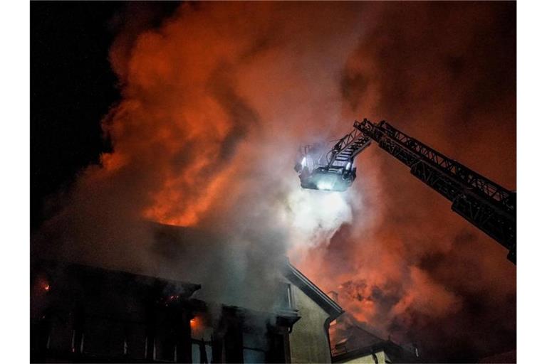 Feuerwehrleute bekämpfen einen Dachstuhlbrand. Foto: Kohls/SDMG/dpa