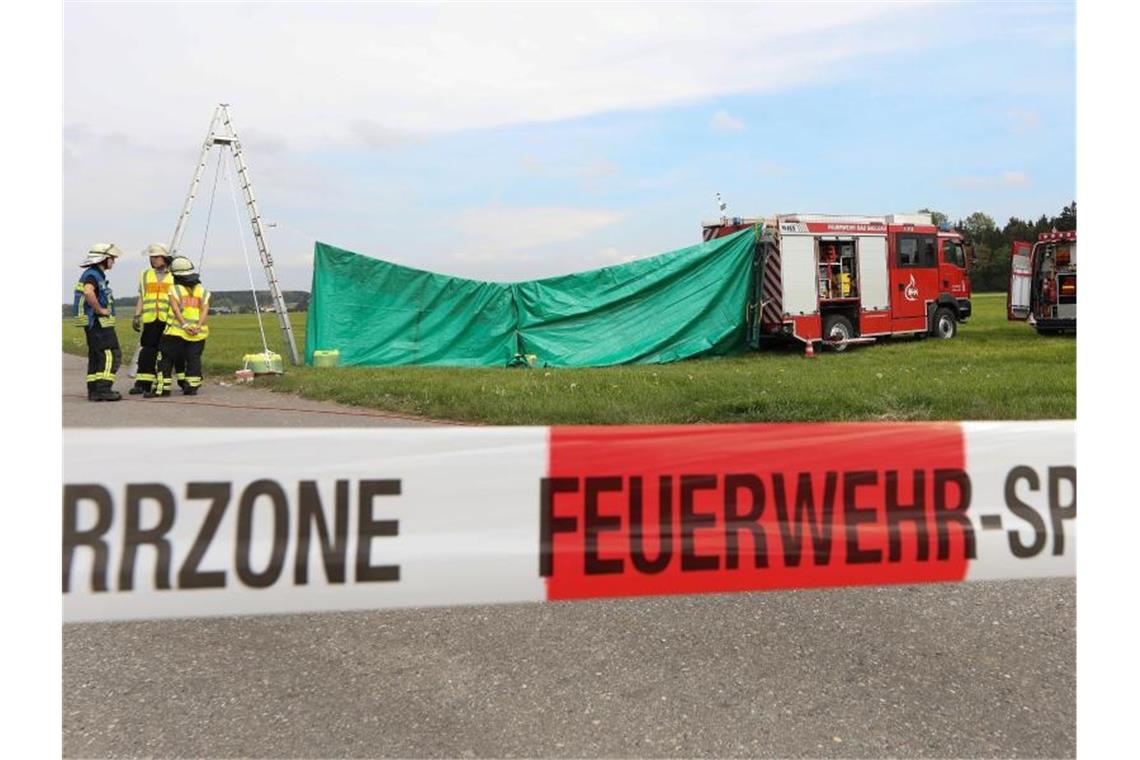 Feuerwehrleute haben auf dem Flugplatz einen Sichtschutz errichtet. Foto: Thomas Warnack