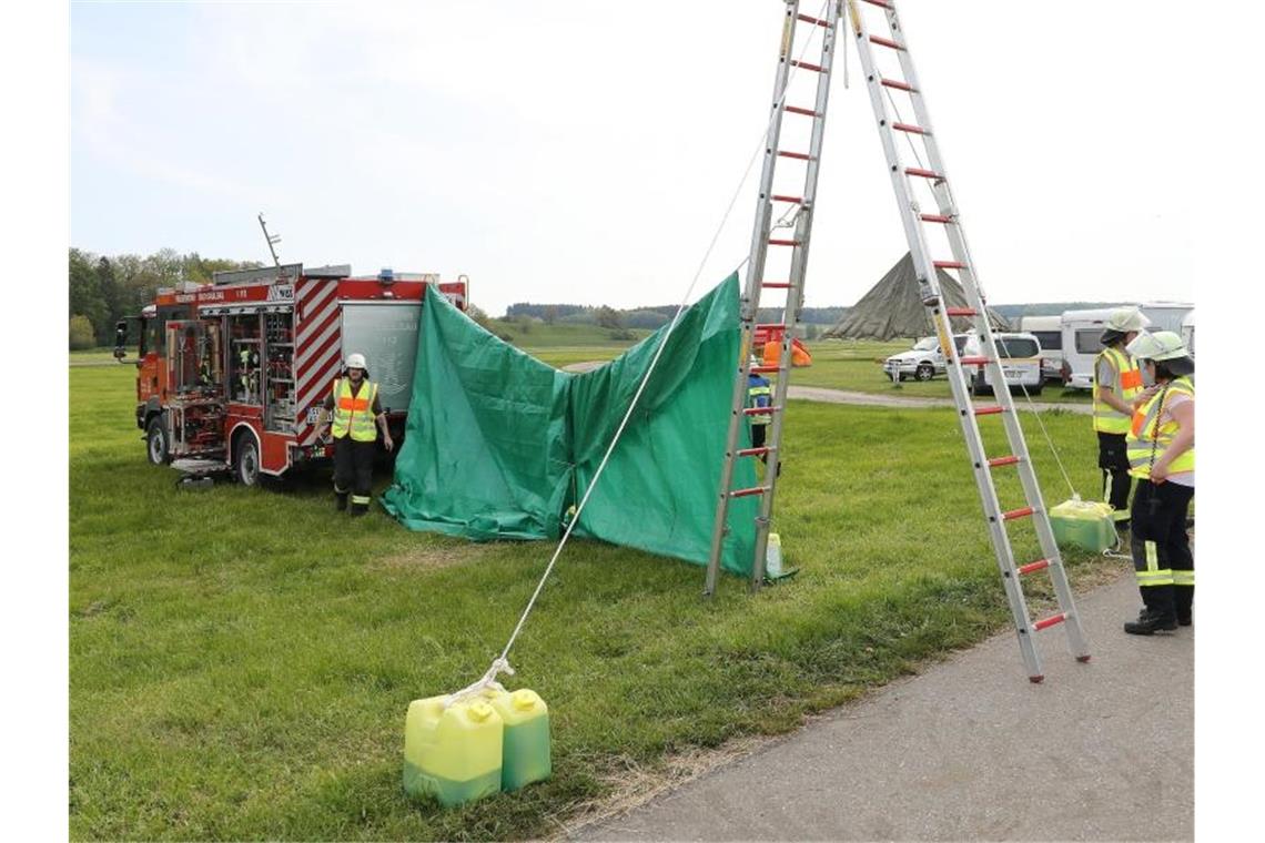 Zwei tote Männer: Fallschirme kollidieren miteinander Feuerwehrleute haben auf dem Flugplatzgelände in Saulgau einen sichtschutz errichtet. Foto: Thomas Warnack