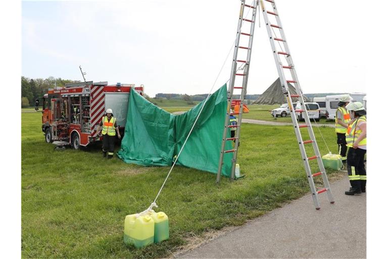 Feuerwehrleute haben auf dem Flugplatzgelände in Saulgau einen sichtschutz errichtet. Foto: Thomas Warnack