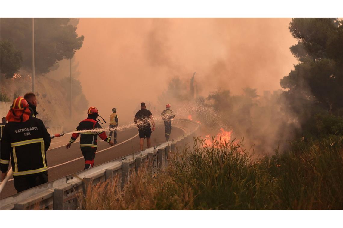 Bilder des Tages Feuerwehrleute löschen Brände neben einer Straße an der kroatischen Adria-Küste. Wald- und Vegetationsbrände wüten in der Region.